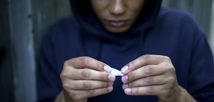 Teenager addict making cigarettes with marijuana, health problems risk, oncology