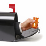 a hand holding a prescription coming out of a mailbox