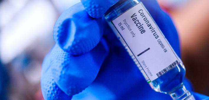 Image of Hand holds Coronavirus Covid-19 Vaccine glass bottle.