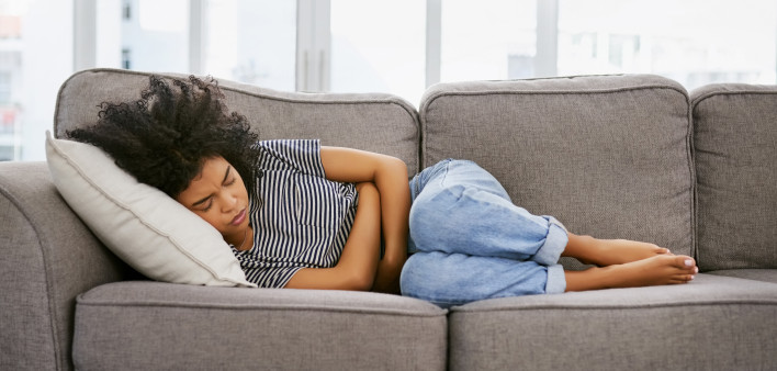 woman girl stomach cramps couch pain