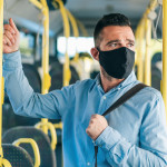 Men with protective face mask traveling with bus, during COVID-19