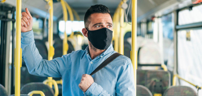 Men with protective face mask traveling with bus, during COVID-19
