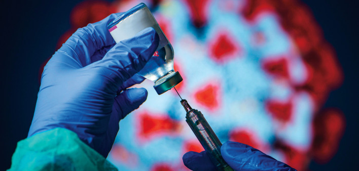 gloved hand needle vial vaccine coronavirus