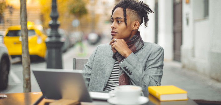 African American young man working outside at cafe