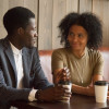 African man and woman talking flirting sitting at coffeehouse table