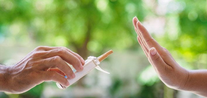 lose up of male hands holding cigarettes and proposing it to person.