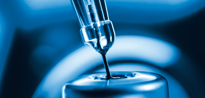 vaccine needle inserted into vial blue