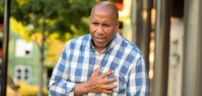 African American man having pains holding his chest.