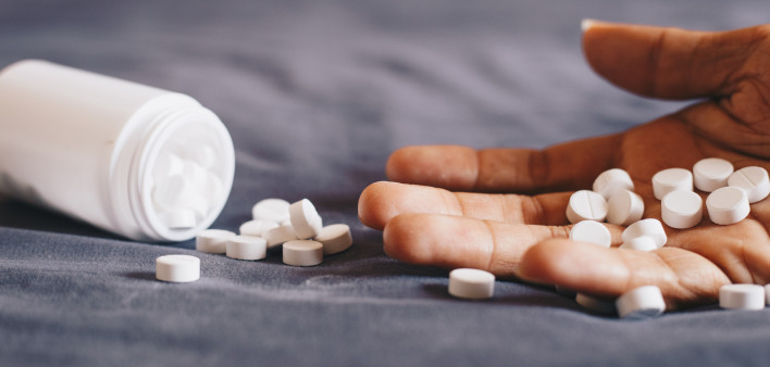 medication in hand, committing suicide by overdosing on medication