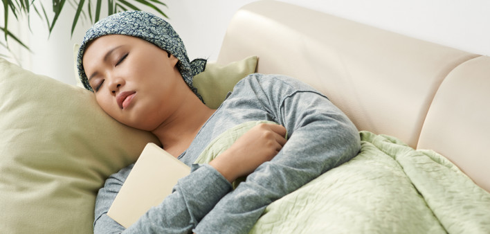 Asian woman with cancer sleeping on couch