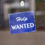 Help wanted sign hanging in window