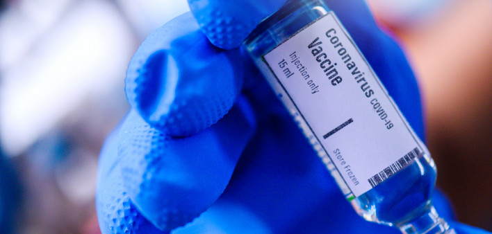 Image of Hand holds Coronavirus Covid-19 Vaccine glass bottle.