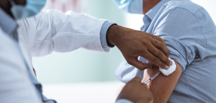 Mature man taking a vaccine from his doctor