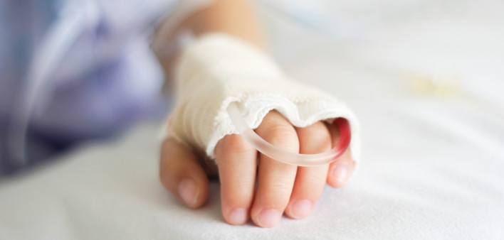 Saline intravenous (iv) drip in a Children's patient hand