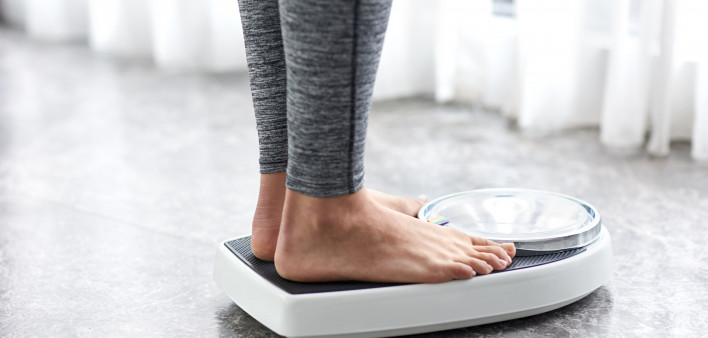 Young healthy girl on home scales