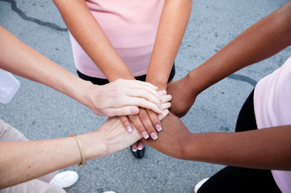 three woman in a circle hands overlapping