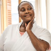 black woman looking at and touching her face in the mirror