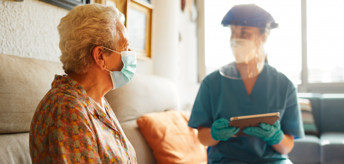 A female doctor visits a senior woman at the nursing home