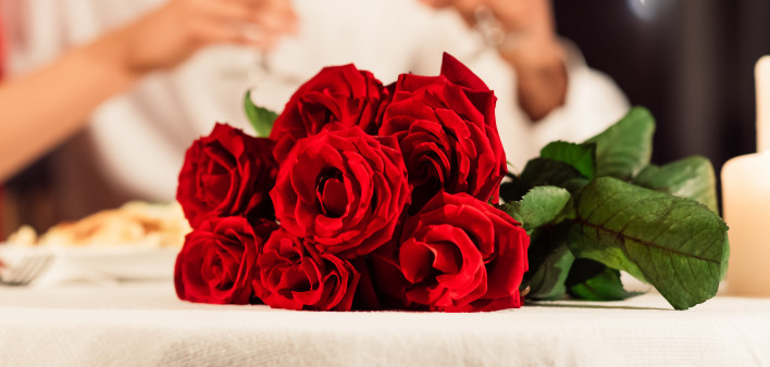 Valentine's Romantic Date. Red Roses Lying On Table, Unrecognizable Spouses Drinking Wine In