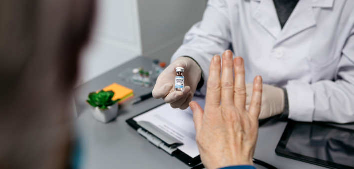 Female patient refusing the coronavirus vaccine offered by her doctor