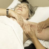A woman's swollen arm is palpated by a doctor