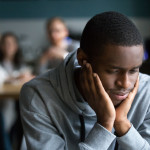 Black guy sit alone in cafe suffering from racial discrimination