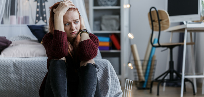 young woman depress holding head in bedroom