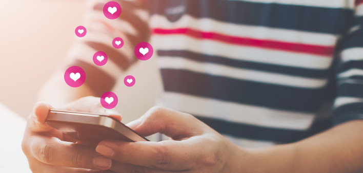 Social network sharing and commenting in the online community, Man hand holding smartphone and using application social media with icon heart