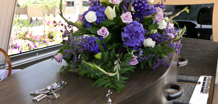 coffin with flower arrangement on top