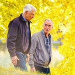 Senior gay couple enjoying a walk sunny Autumn day