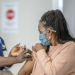 A senior female is receiving her COVID-19 vaccine