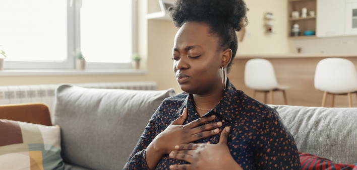 Pressure in the Chest. Close-up Photo of a Stressed Obese African American Woman Who Is Suffering From a Chest Pain and Touching Her Heart Area.