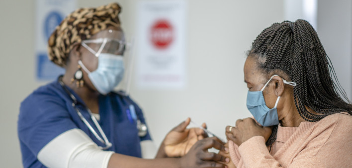 A senior female is receiving her COVID-19 vaccine