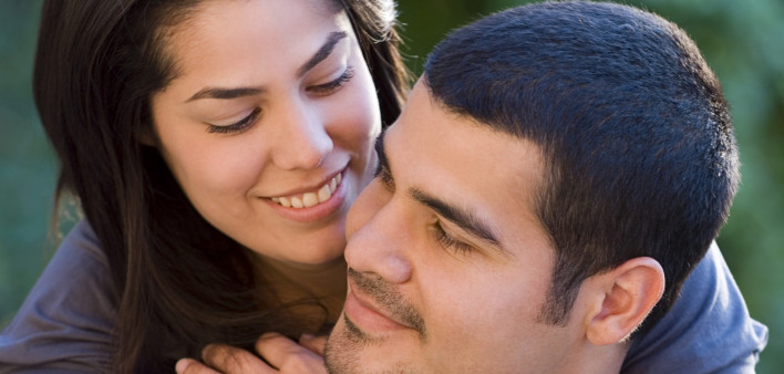 Latin couple playing piggyback and smiling