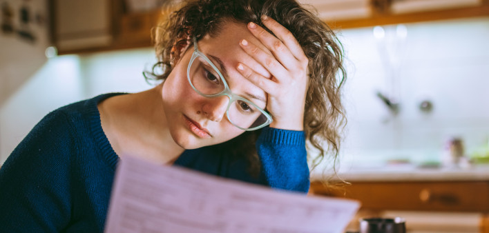 Woman going through bills, looking worried
