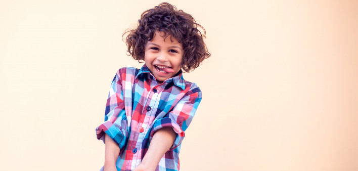 Closeup portrait of shy little kid with curly hair