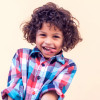 Closeup portrait of shy little kid with curly hair