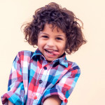 Closeup portrait of shy little kid with curly hair
