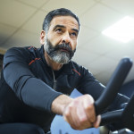 mature man exercise bike gym spin
