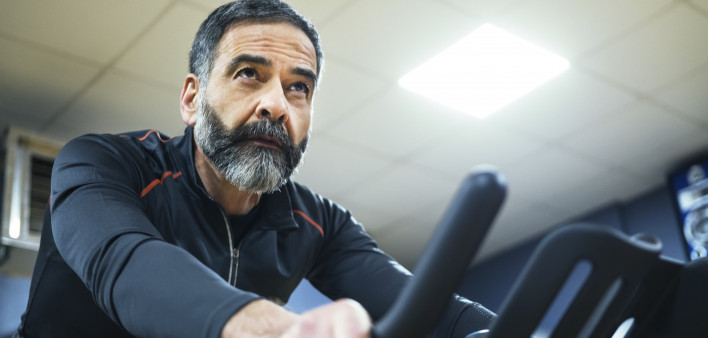 mature man exercise bike gym spin