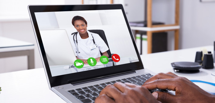 Close-up Of A Person Video Conferencing With Female Doctor Through Laptop