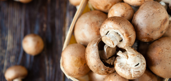 Champignons in a basket on dark boards mushrooms
