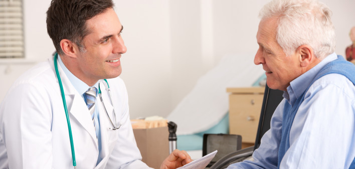 American doctor talking to senior man in surgery