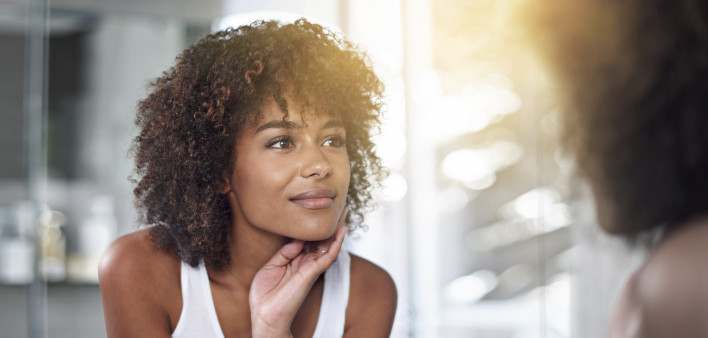 An African American woman looking in a mirror