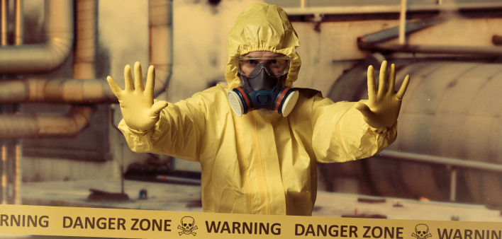 man in protective yellow gear and gas mask danger zone