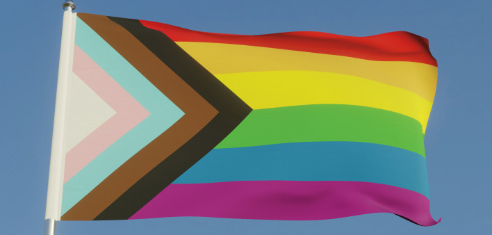 Inclusive LGBTQI+ Pride Flag Fluttering against a blue sky