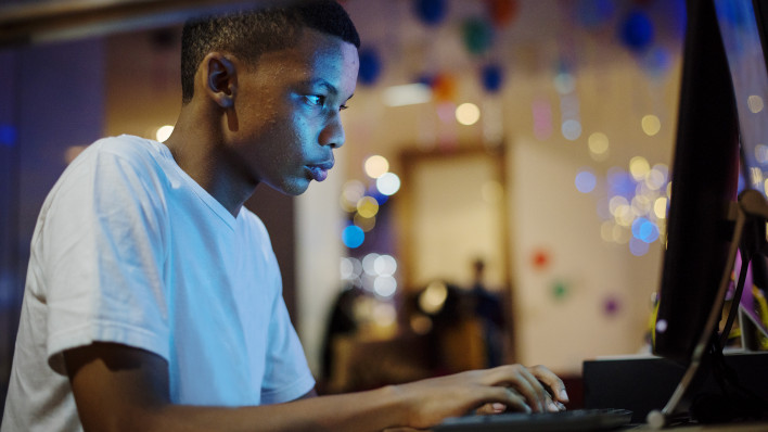 African american boy using a computer at night