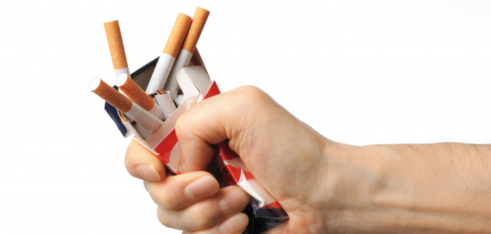 Hand crushing box of cigarettes