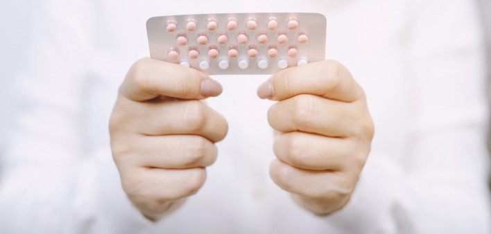 Woman hands opening birth control pills