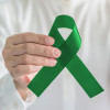 hand with green ribbon cerebral palsy and liver cancer awareness